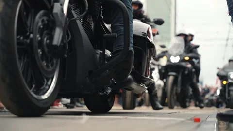 Motorcycle parade riding through a crowd, passing close to the camera at ground  Stock Footage 314139121