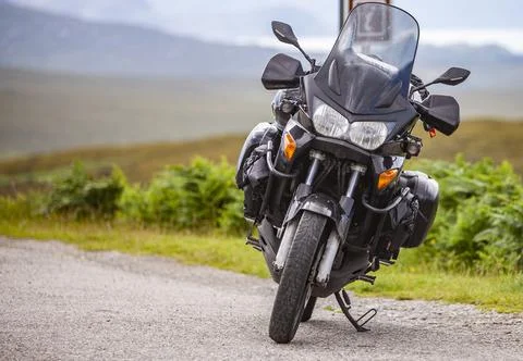 A motorcycle parked on the side of a road Stock Photos