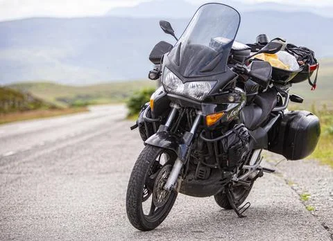 A motorcycle parked on the side of a road Stock Photos