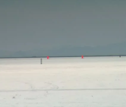 Motorcycle passes camera at high speed on Bonneville salt Flats Stock Footage 21642733