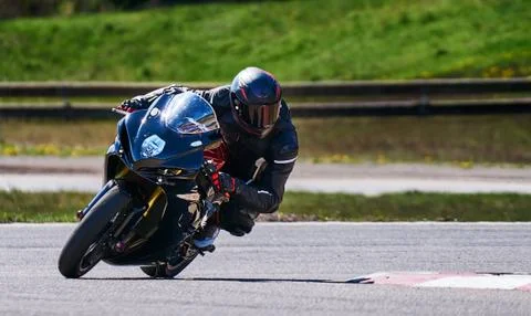 Motorcycle practice leaning into a fast corner on track Stock-Fotos