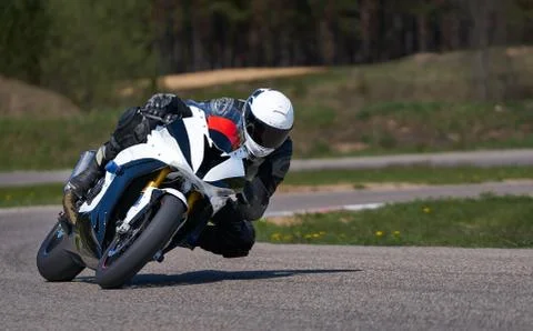Motorcycle practice leaning into a fast corner on track 库存照片