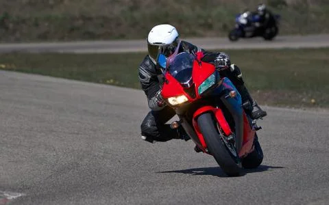 Motorcycle practice leaning into a fast corner on track Photos