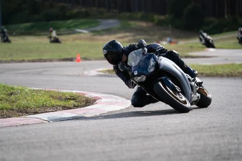 Motorcycle practice leaning into a fast corner on track 库存照片