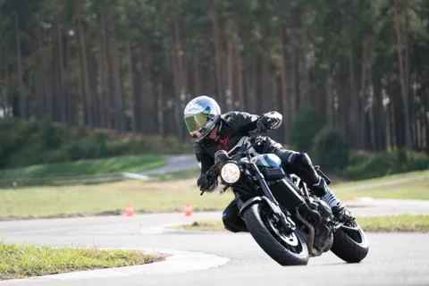 Motorcycle practice leaning into a fast corner on track 库存照片
