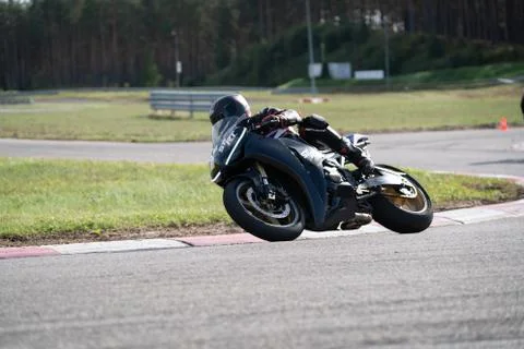 Motorcycle practice leaning into a fast corner on track 库存照片