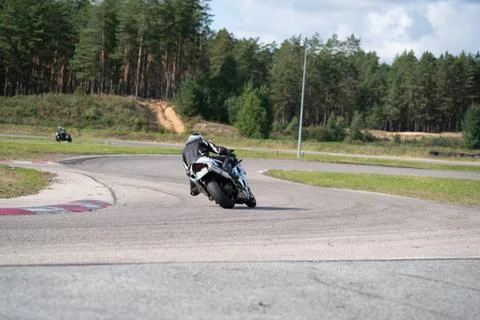 Motorcycle practice leaning into a fast corner on track 库存照片