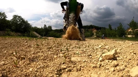 Motorcycle rider accelerates through rugged terrain, showcasing dynamic movement Video stock 320479200
