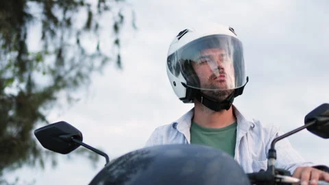 The motorcycle rider flips down his helmet visor. Stock Footage 312639045