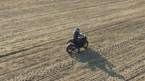 The motorcycle rides the field Stock Footage 80195315