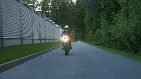 Motorcycle rides on the road in the forest Stock Footage 147554406
