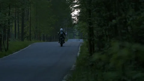 Motorcycle rides on the road in the forest Stock Footage 147554430