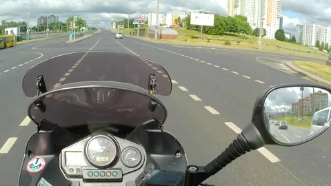 A MOTORCYCLE RIDES THROUGH THE CITY 動画素材 243089734