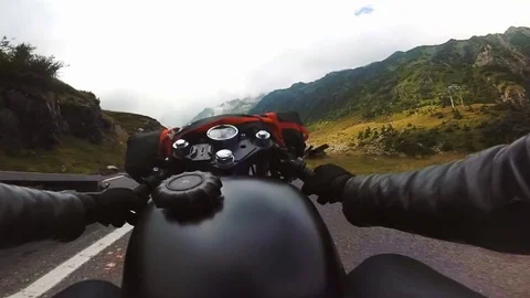 Motorcycle riding down the mountain road on a nice cloudy day. Stock Footage 78225304