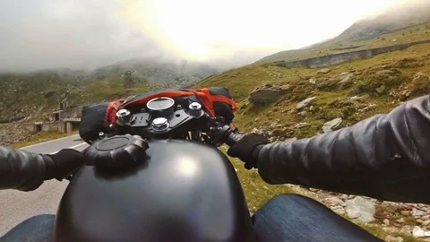 Motorcycle riding down the mountain road on a nice cloudy day. Stock Footage 78225999