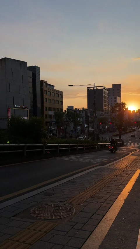 Motorcycle Riding Down an Urban Road During Golden Sunset Rush Hour Stock Footage 340410003