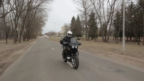 The motorcycle rushes down the road. Crane shot. Stock Footage 75707919