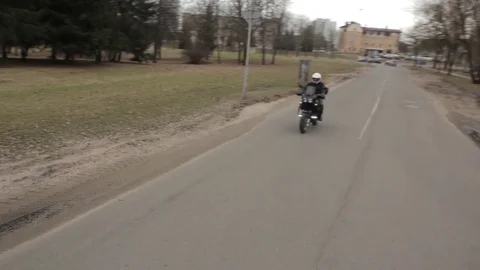 The motorcycle rushes down the road. Crane shot. Stock Footage 75861782