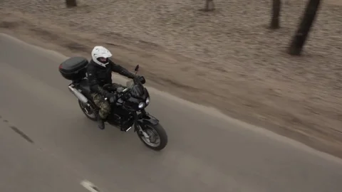 The motorcycle rushes down the road. Crane shot. Stock Footage 75863365