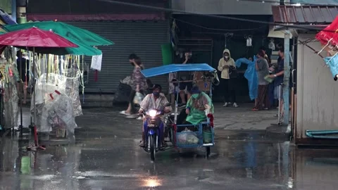 A motorcycle with a sidecar drives through a rainy street Stock Footage 233232674