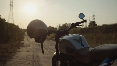 A motorcycle silver helmet hangs on the handlebars of a motorcycle. Stock Footage 253449930