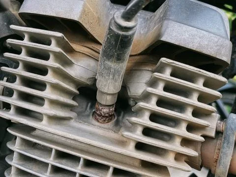 Motorcycle spark plug connected to ignition coil cable Stock Photos