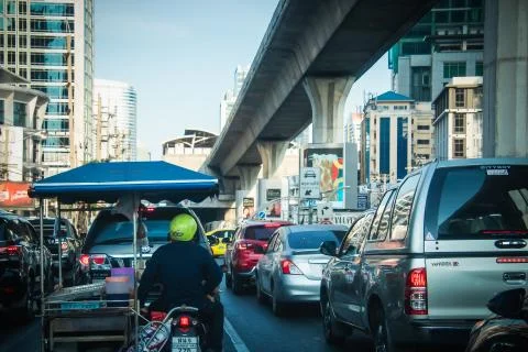 A motorcycle trailer stuck in the middle of a car on Sathorn road Bangkok   Stock Photos