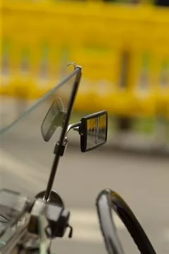 Motorcycle windshield and mirror with blurred yellow background Stock Photos