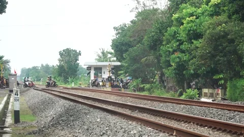 Motorcycles cross the tracks after the train passes and the railroad crossi.. Stock-Footage 280093254