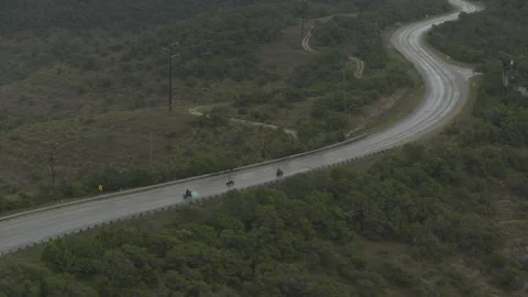 Motorcycles race down a bend in the road in the countryside Stock Footage 323479232