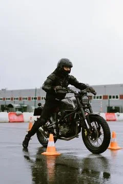 Motorcyclist performing a maneuver in a training session on rainy day Photos