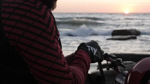 Motorcyclist puts on gloves preparing for evening ride Stock Footage 145322300
