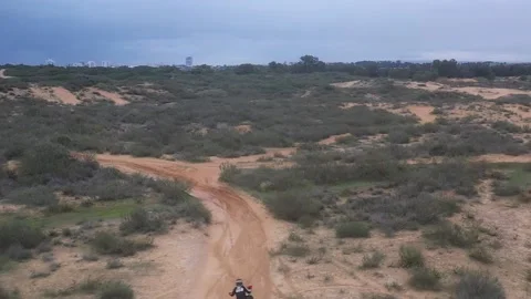 A motorcyclist rides in the dunes Stock Footage 168550622