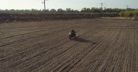 A motorcyclist rides the field Stock Footage 80577417