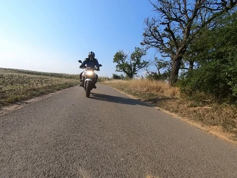 Motorcyclist rides on a highway with back light Stock Footage 93664774