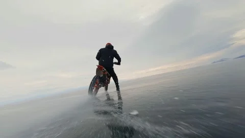 A motorcyclist rides on ice. Dynamic flyby from a drone Stock Footage 222046704