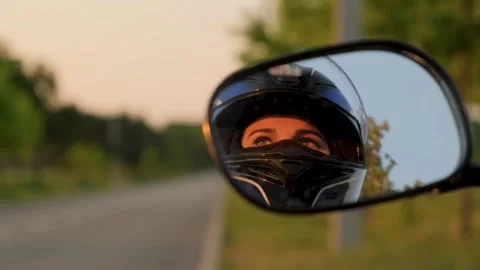 A motorcyclist's face in the rearview mirror. Focus changes to the road Stock Footage 305075663