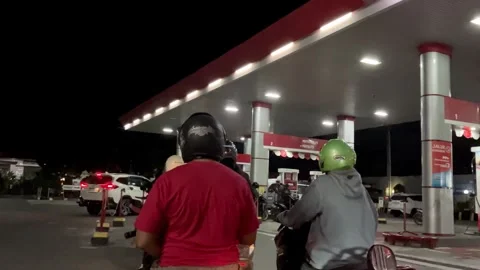 Motorcyclists lining up at gas station to refuel at night. Stock Footage 345520011