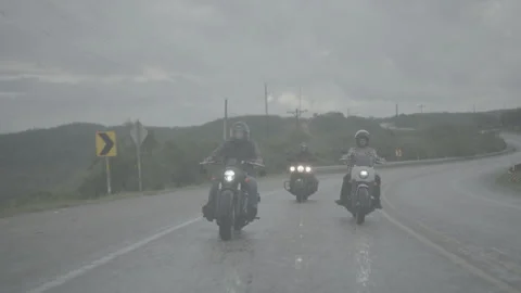 Motorcyclists make turn on the road in the rain Stock Footage 323478991