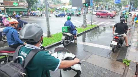 Motorcyclists navigate a busy intersection in Ho Chi Minh City, Vietnam on a Stock Footage 334897288