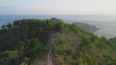 Motorcyclists pass along a path on a hill Stock Footage 292371210