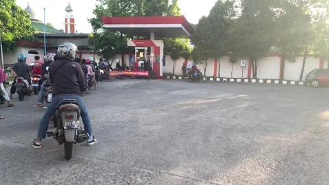 Motorcyclists queue to refuel their vehicles at a gas station Stock-Footage 241258139
