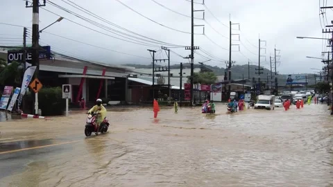 Motorcyclists struggle to ride through the streams of water on the road Stock Footage 219782833