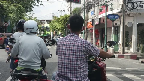 Motorcyclists wait at an intersection with traffic lights Stock Footage 240004860