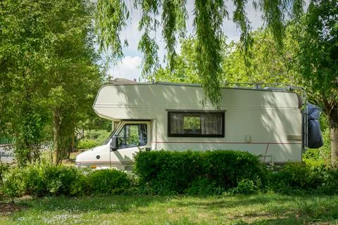 Motorhome parked between trees in the middle of nature Stock Photos