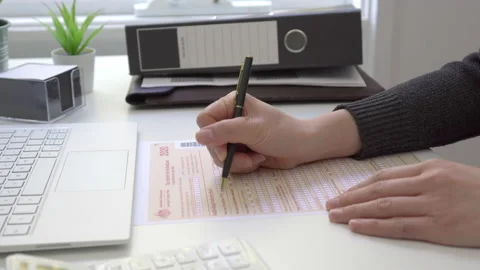 Motorized jib shot of completing Australian tax form Stock Footage 137216524