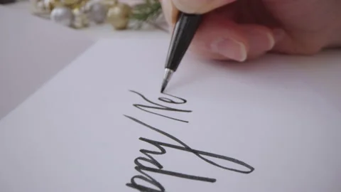 Motorized macro moving shot of writing Happy New Year on a greeting card Stock Footage 221029307