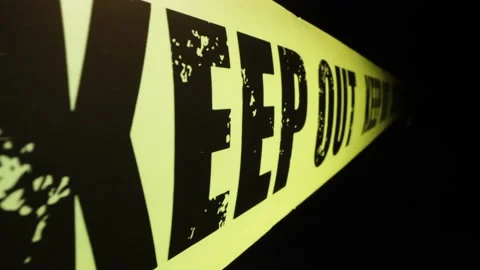 Motorized moving shot of keep out tape against dark background Stock Footage 150411099