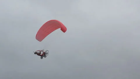 Motorized paraglide flying in the dark clouds Vídeo Stock 260366450