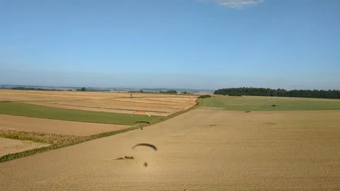 Motorized paragliding pilot flying low above ground enjoying powered flight 库存影片 334684028